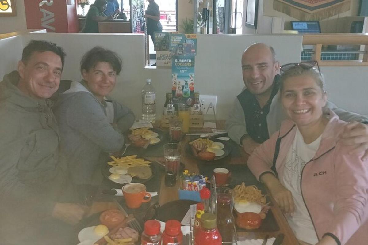 un grup de persones assegudes al voltant d'una taula amb menjar