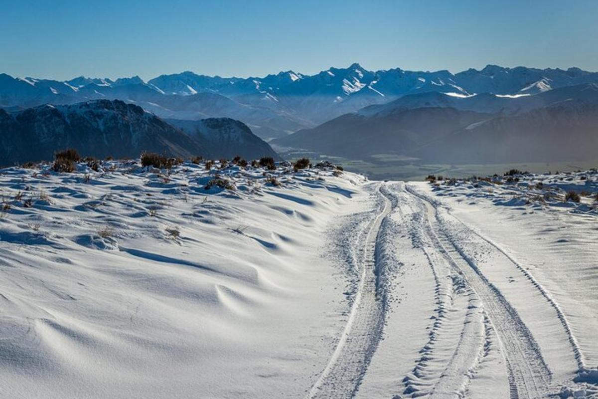 a snow covered mountain with tracks in the snow