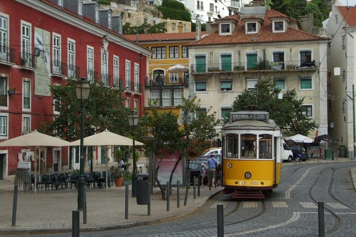 Žlutá tramvaj na městské ulici s budovami