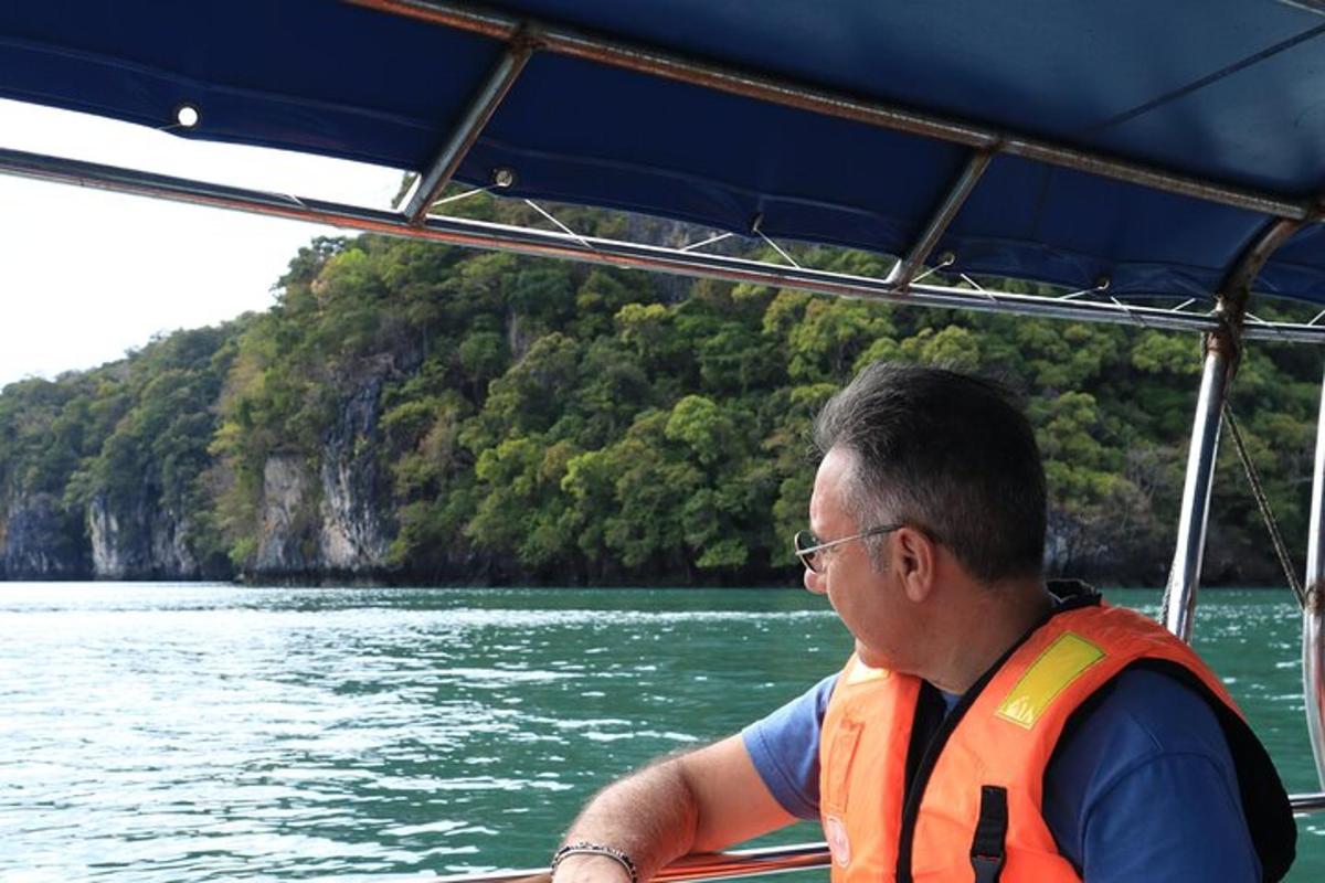 Un hombre con un chaleco naranja en un barco en el agua.
