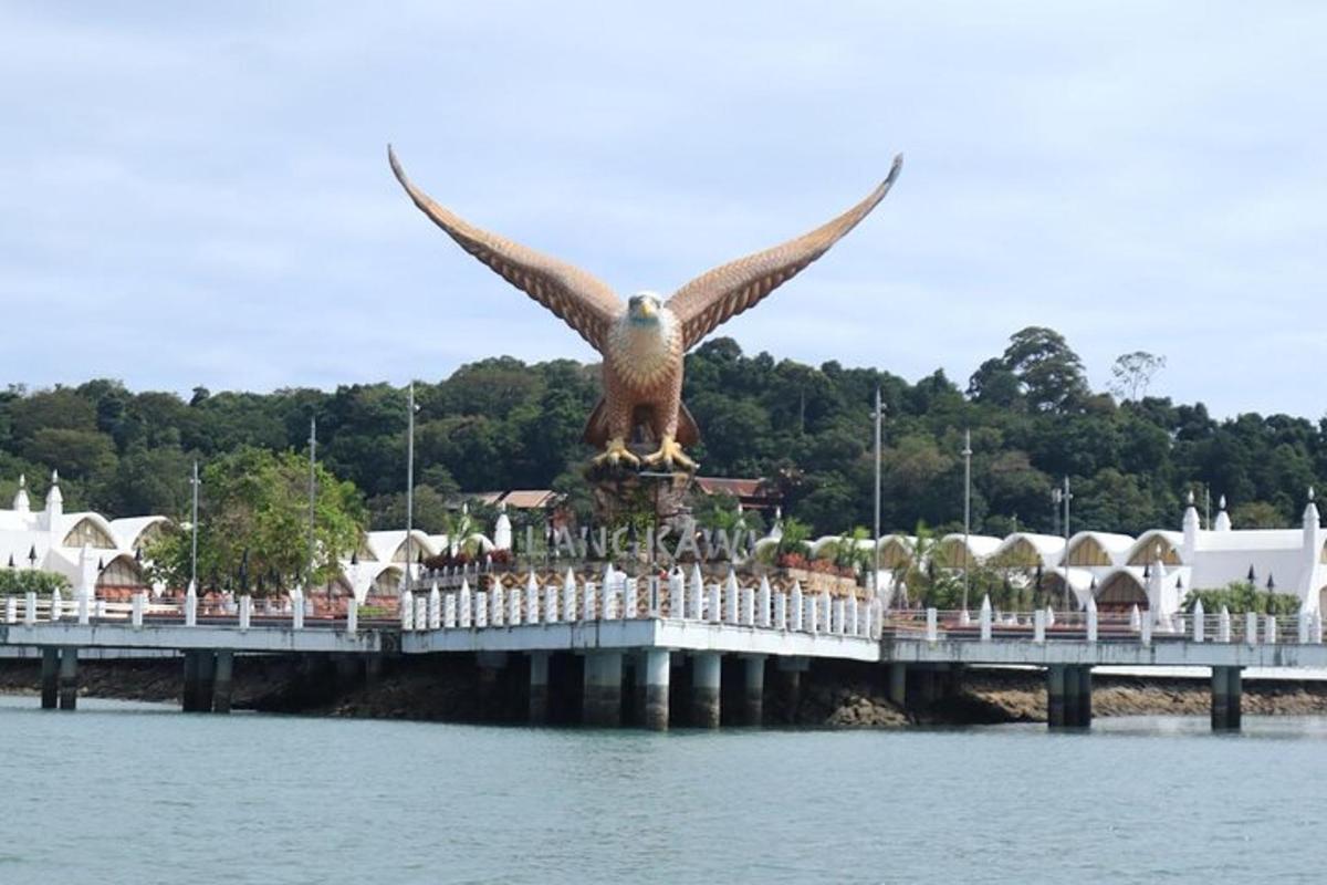 una estatua de un águila en un muelle junto al agua