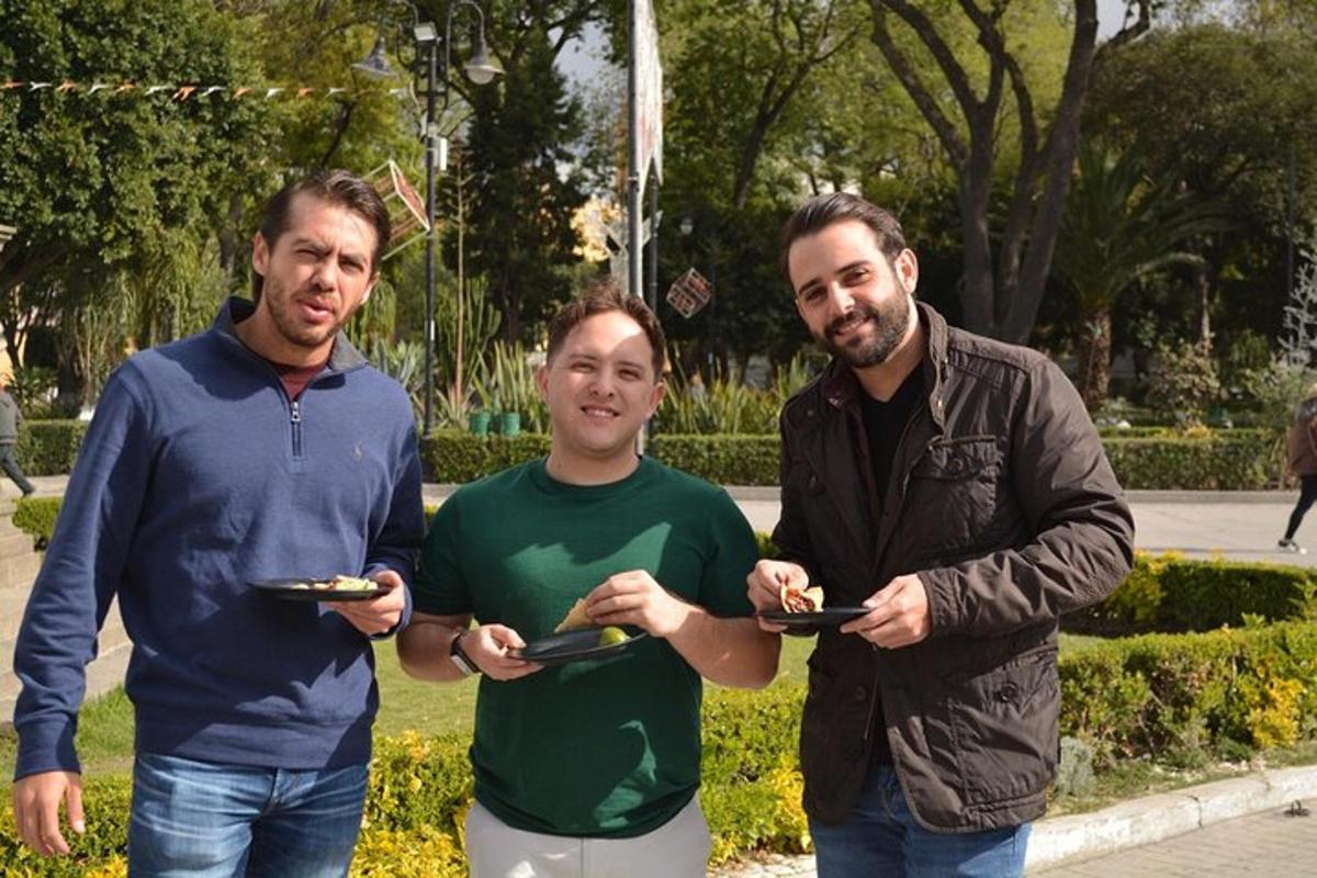 three men standing next to each other holding plates