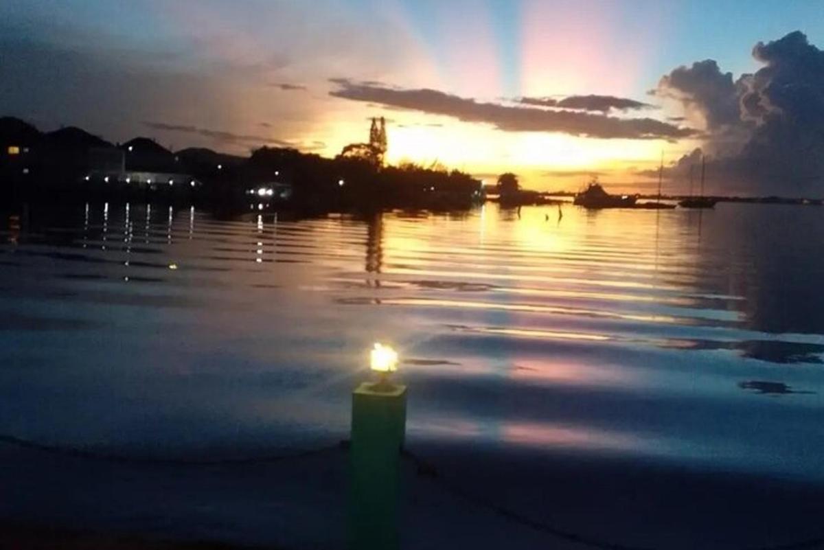a lit candle sitting on the water at sunset