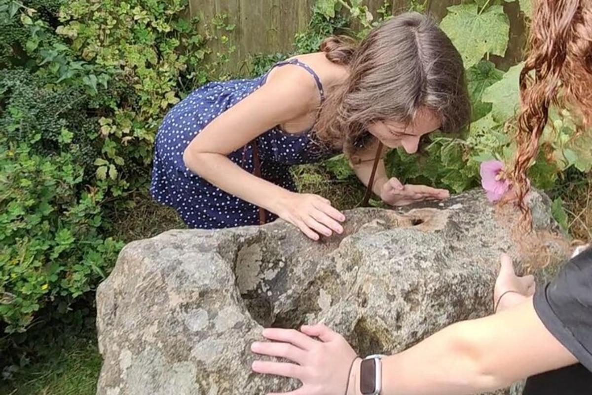 zwei Frauen betrachten eine Eidechse auf einem Felsen