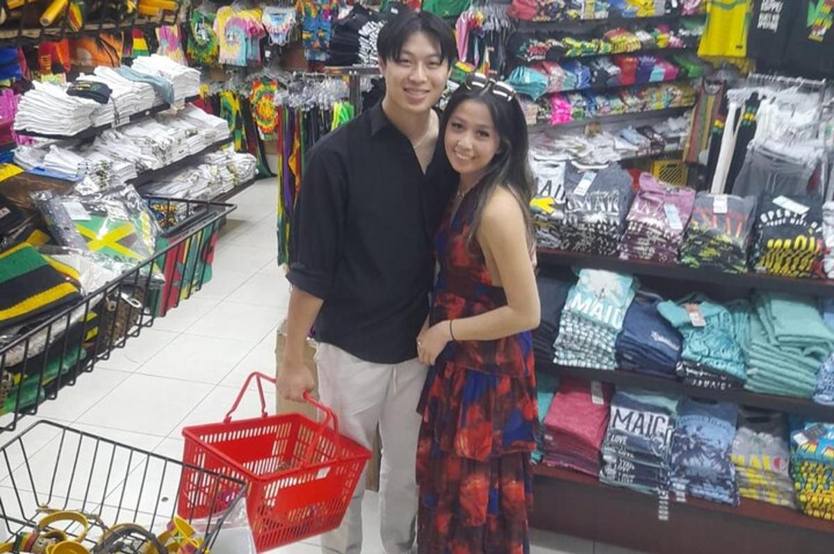 um homem e uma mulher em pé em uma loja com um carrinho de compras