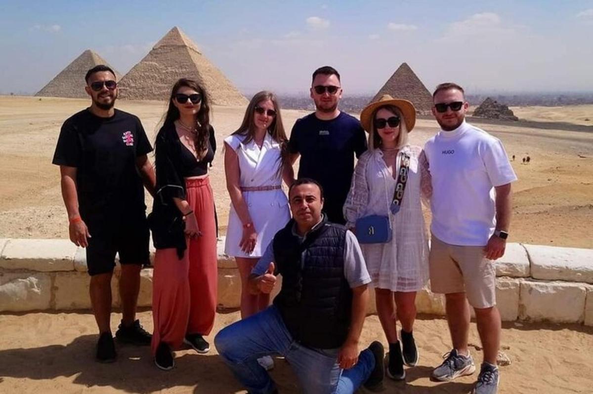 Skupina lidí pózujících před pyramidami