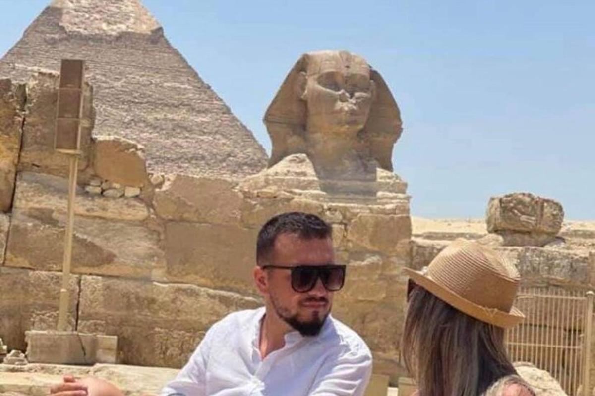muž a žena stojící před pyramidami