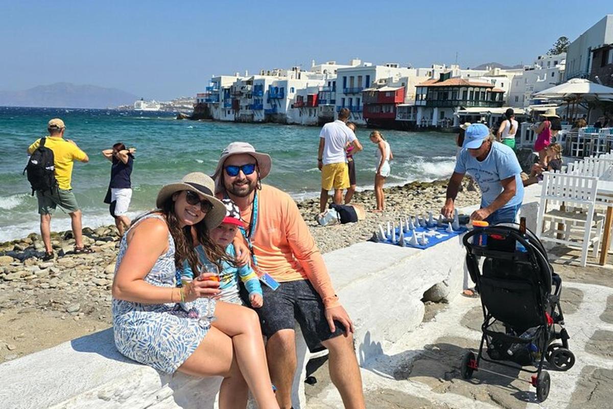 un uomo e una donna seduti sulla spiaggia con un bambino
