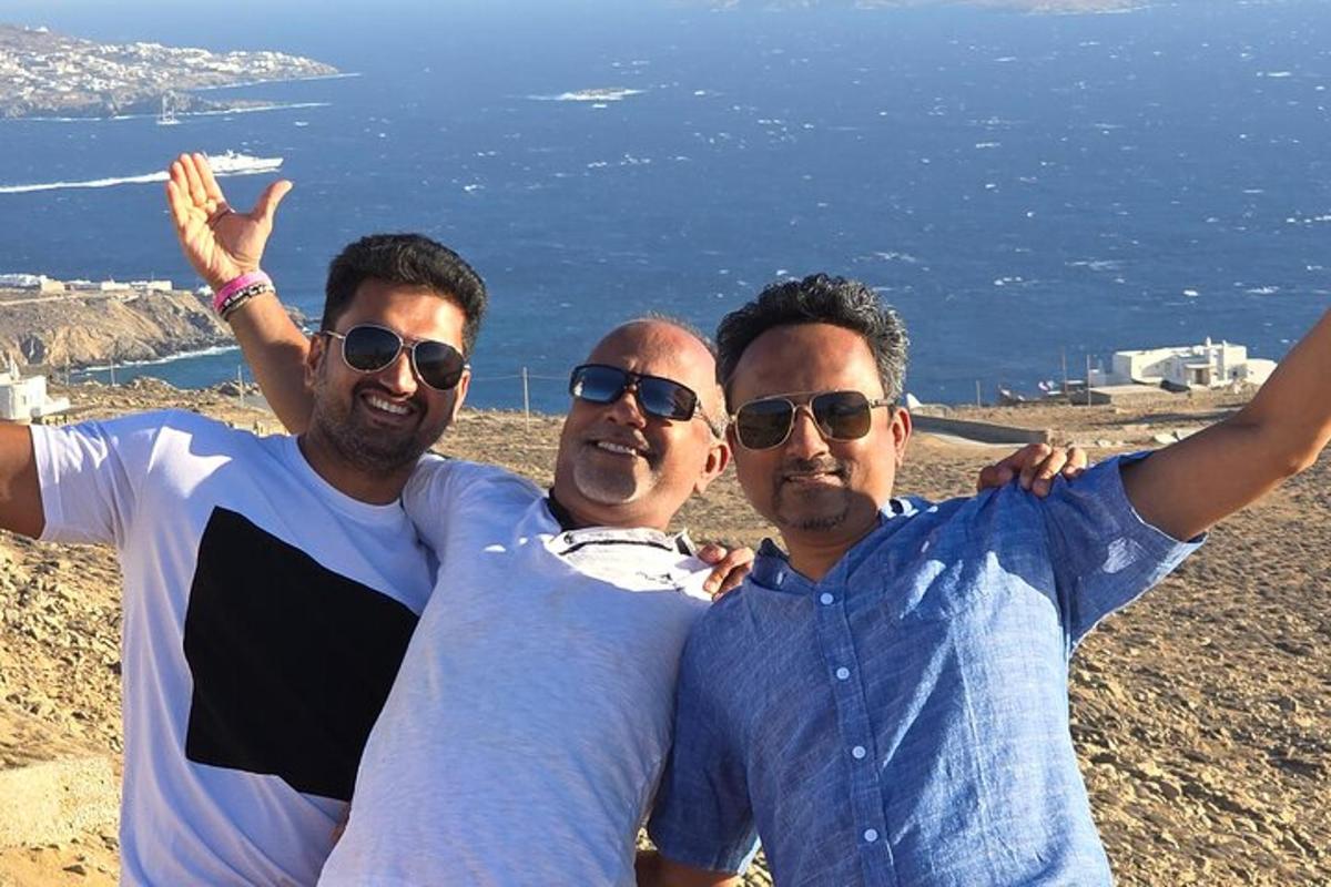 trois hommes posant pour une photo au sommet d'une montagne