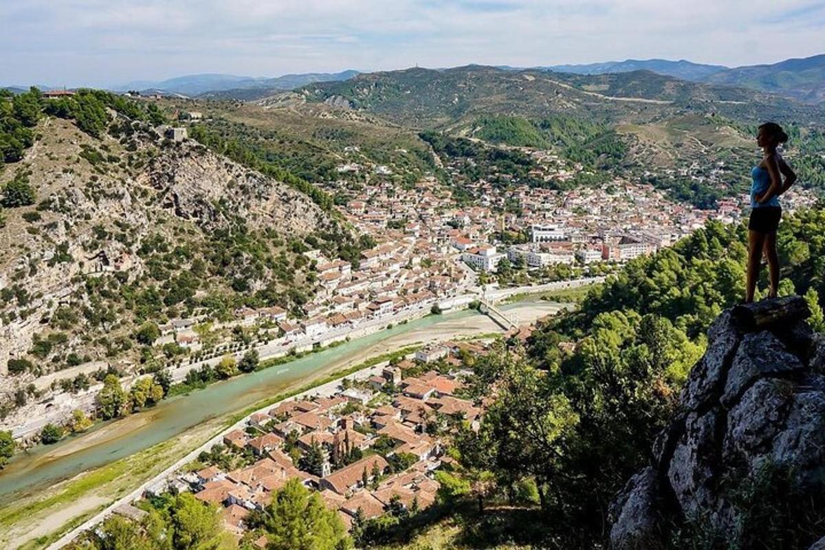 oseba, ki stoji na vrhu gore s pogledom na mesto