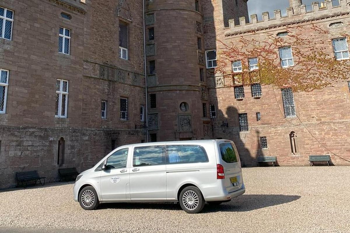 a white van parked in front of a castle