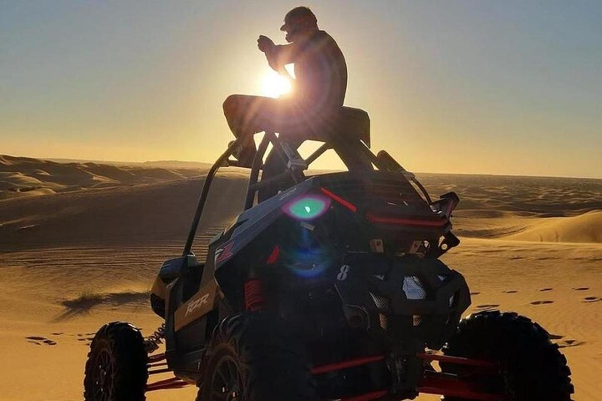 un uomo seduto su un quad nel deserto