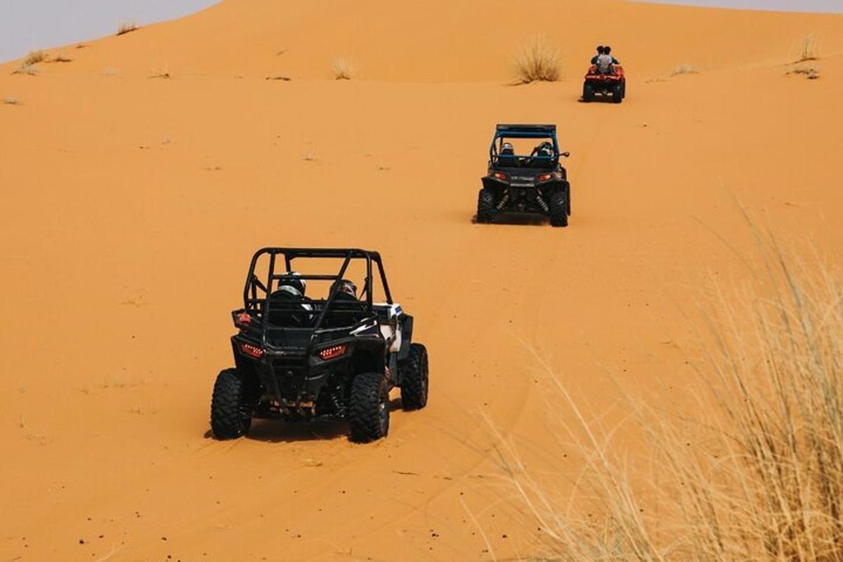 due quad che guidano sulla sabbia nel deserto