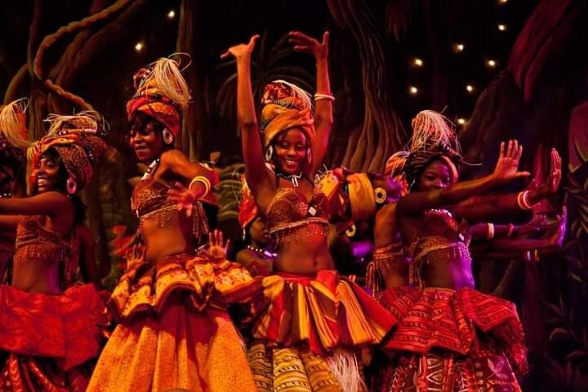a group of women in costumes on a stage
