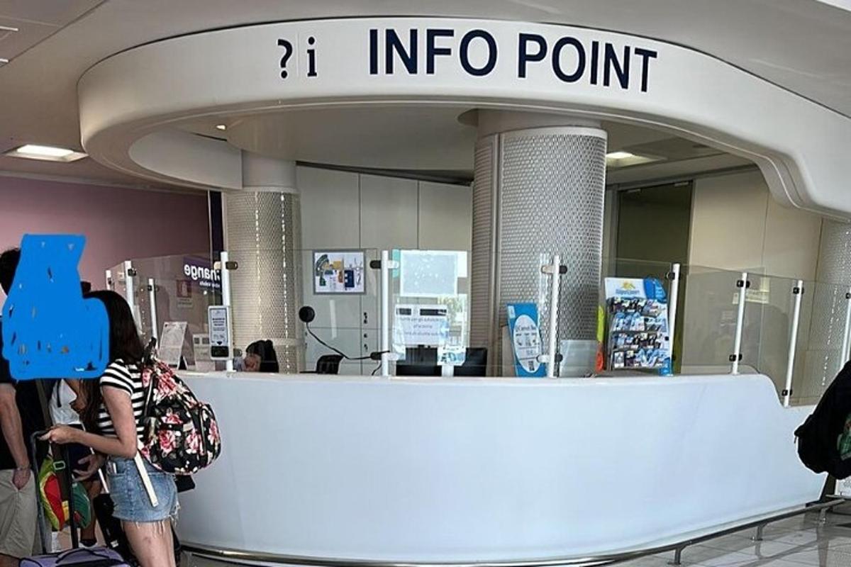 mensen staan bij een informatiepunt op een luchthaven
