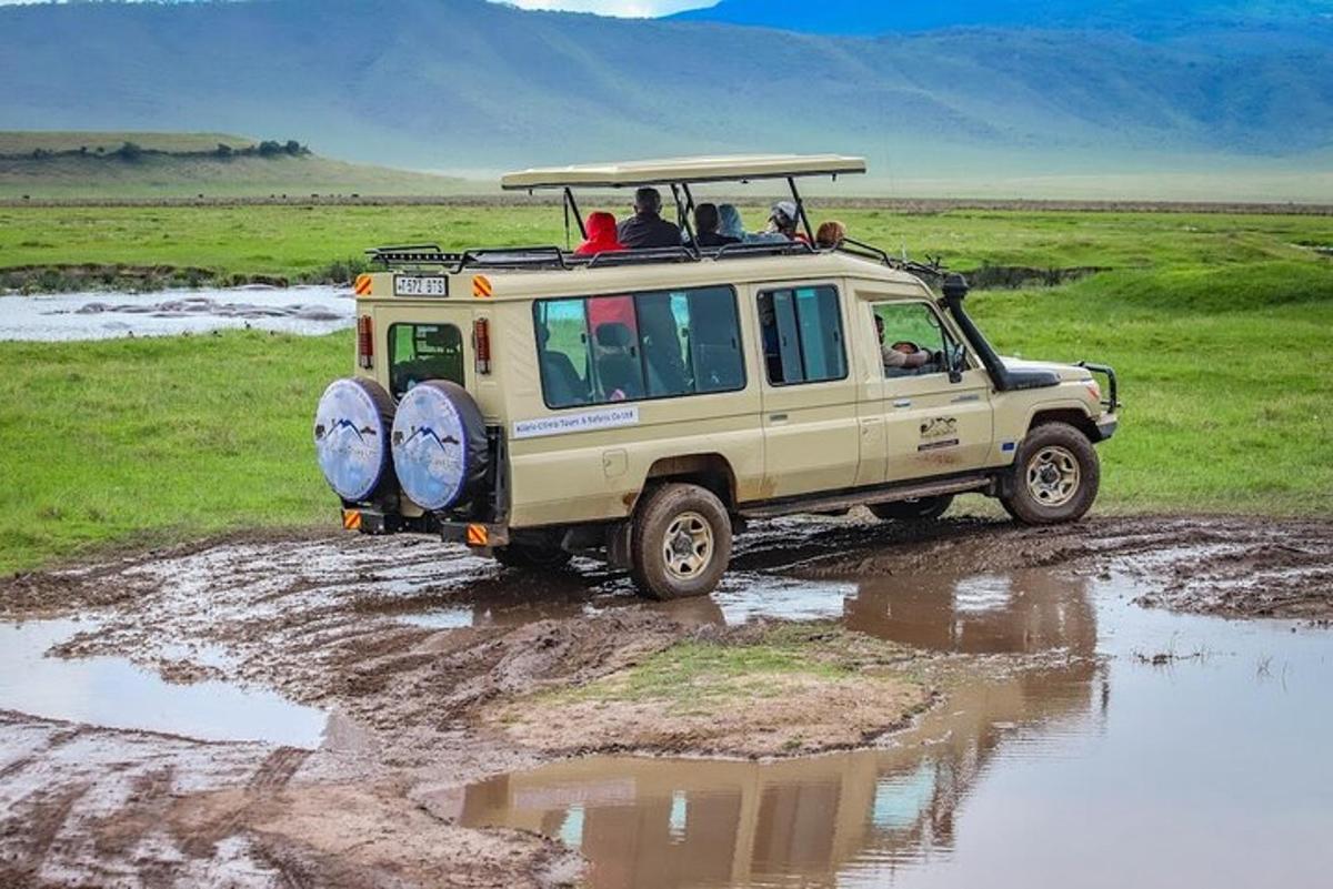 una jeep che guida nel fango in un campo