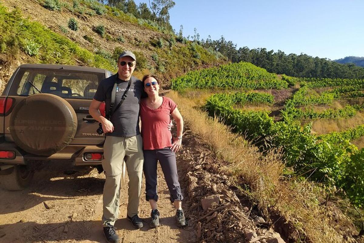 a man and woman standing on a dirt road next to a truck