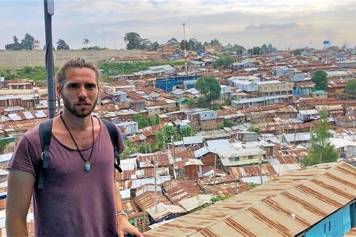 a man with a backpack standing on a roof of a city