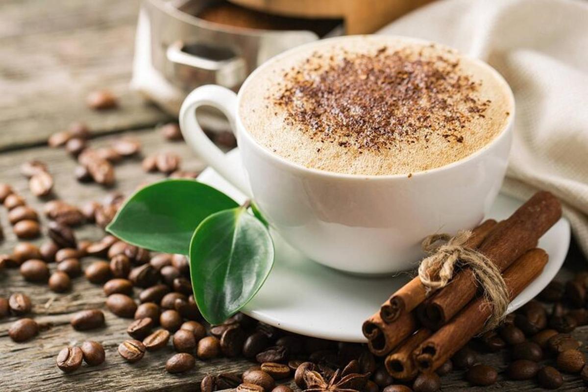 a cup of coffee on a plate with coffee beans