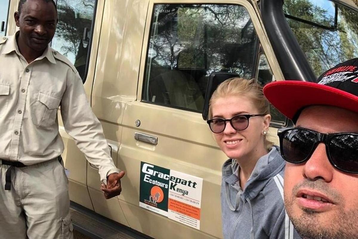 two men and a woman standing in front of a van