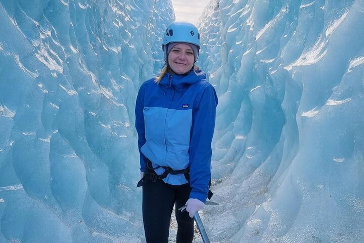 a woman is standing in front of a glacier