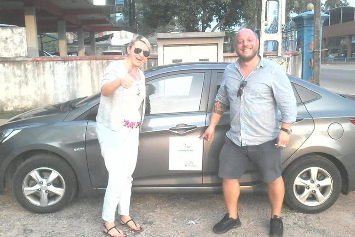 a man and a woman standing in front of a car