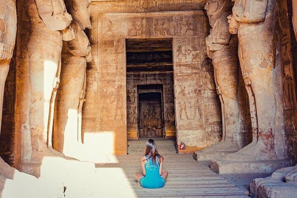 a girl sitting on the steps of an ancient building