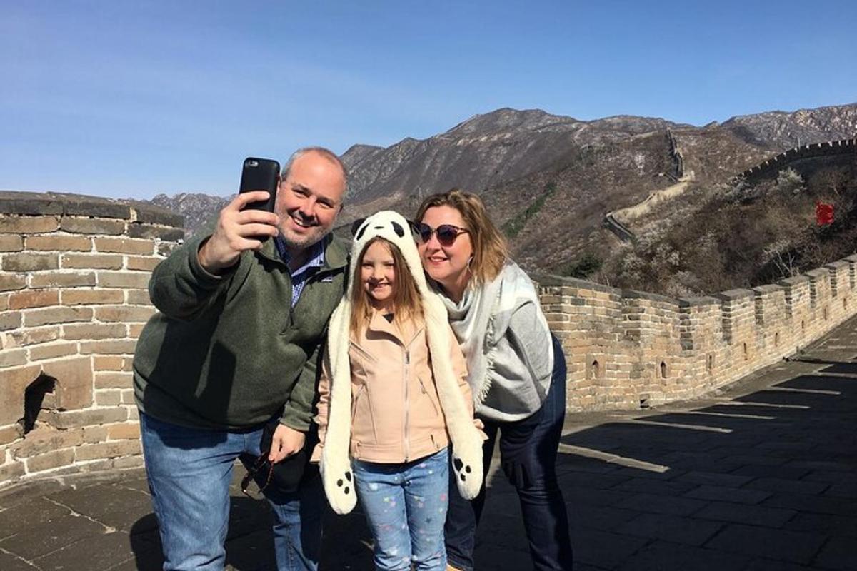 un uomo che scatta una foto a tre persone sulla grande muraglia