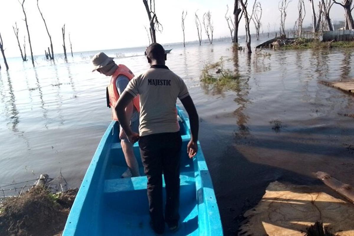 dua lelaki berdiri di dalam sampan biru di dalam air