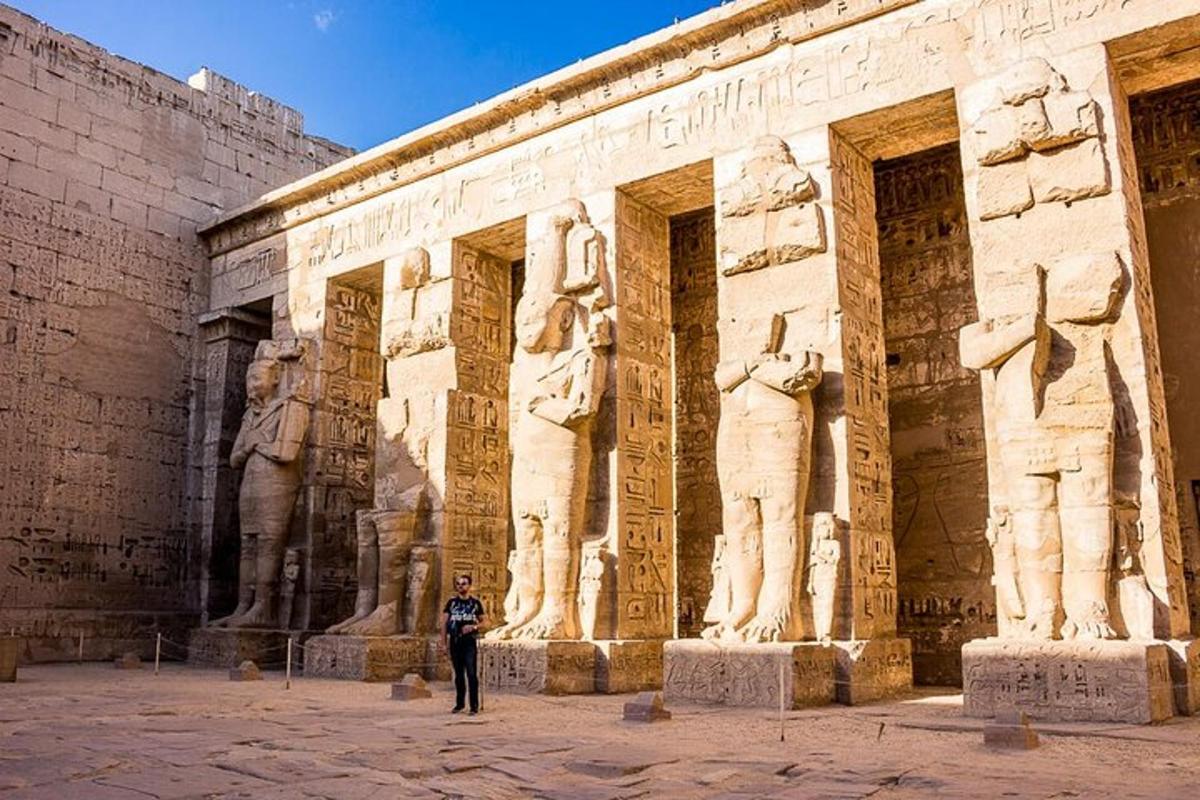 un uomo in piedi davanti a un edificio con statue