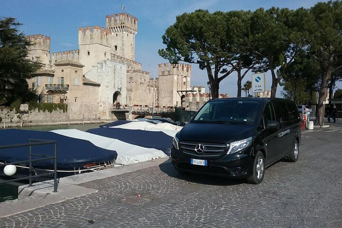 uma van preta estacionada em frente a um castelo