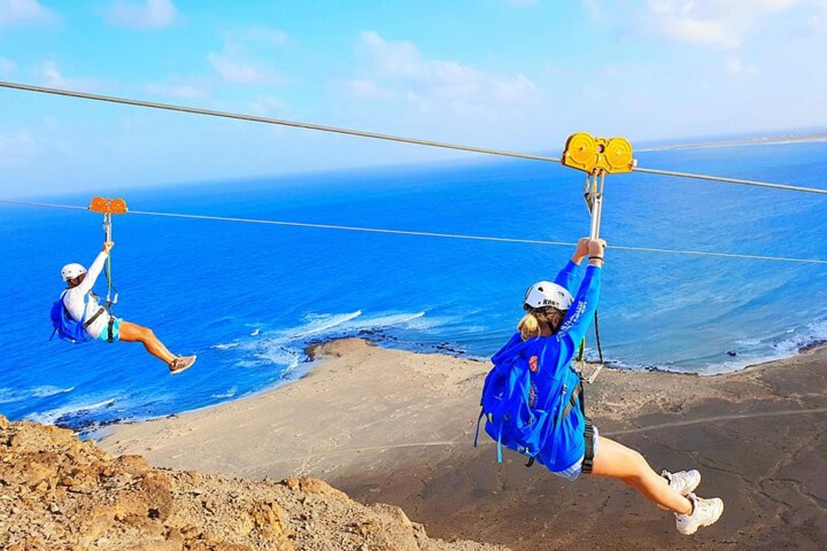 dva lidé na zip line nad oceánem