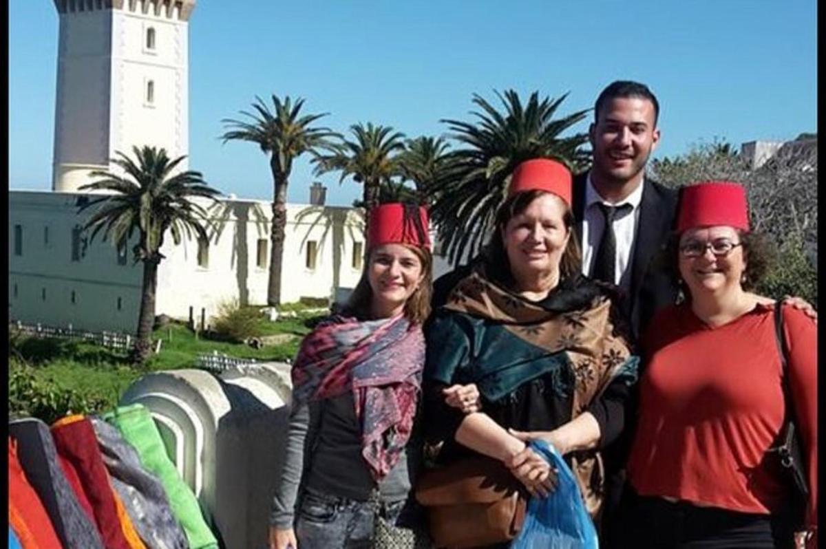 un gruppo di persone che indossano cappelli rossi davanti a un faro
