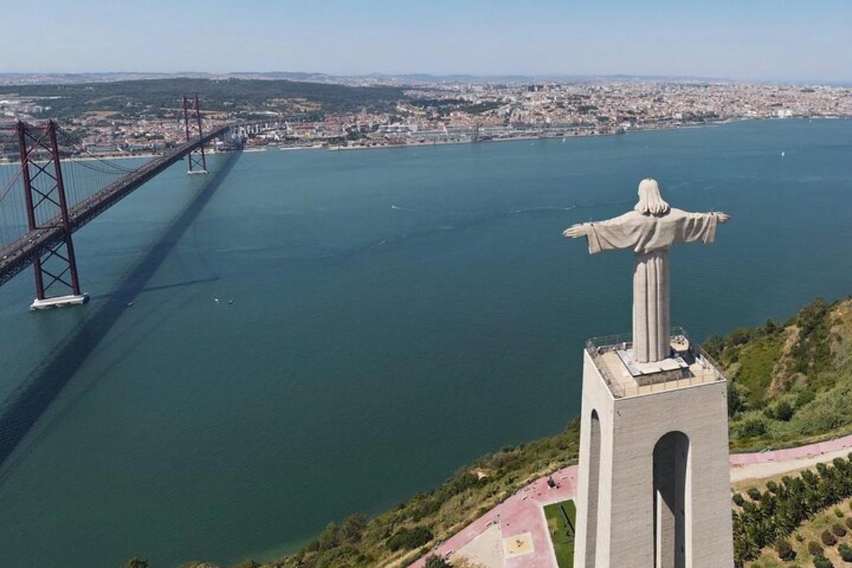 a statue of a cross on top of a tower next to a bridge