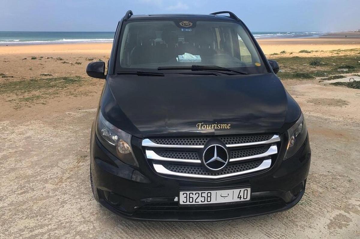 a black mercedes benz car parked on the beach