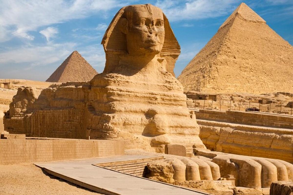 uma estátua da esfinge em frente às pirâmides