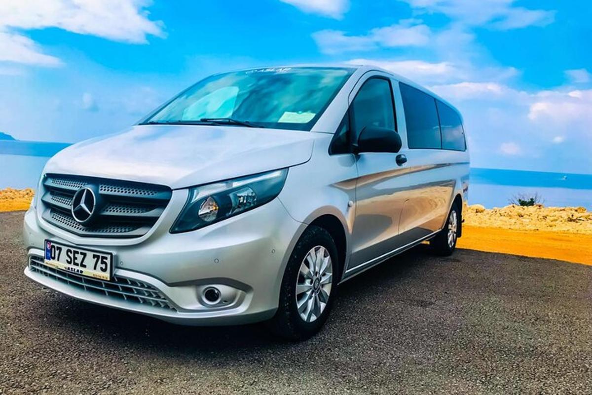 a silver mercedes benz van parked next to the beach