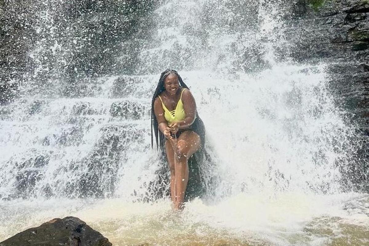 жена, стояща във водата във водопад