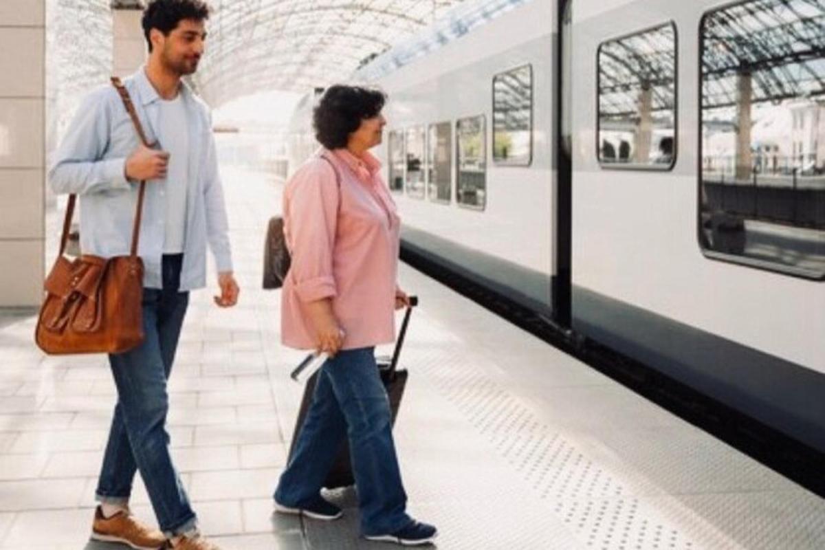 um homem e uma mulher caminhando ao lado de um trem