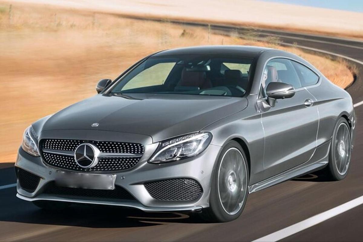 una Mercedes Benz argentata che percorre una strada