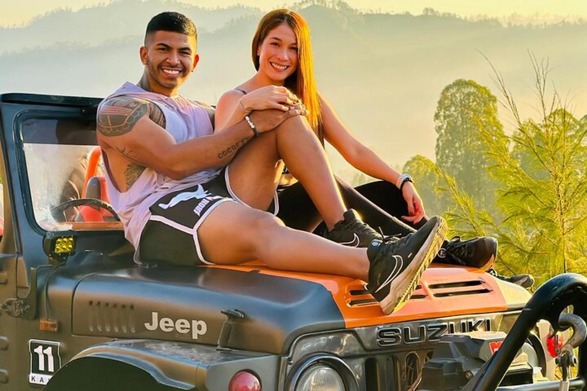 muž a žena sedící na zadní straně džípu
