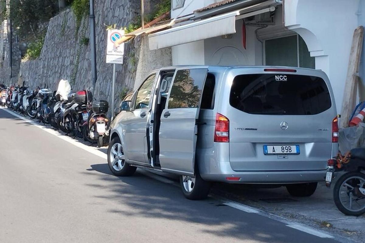 stříbrná dodávka zaparkovaná vedle řady motocyklů
