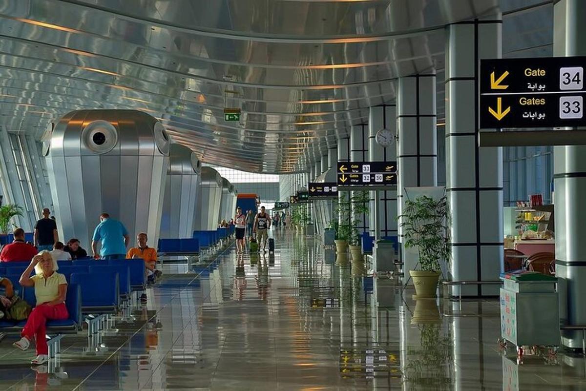 um corredor de aeroporto com pessoas sentadas em mesas no terminal