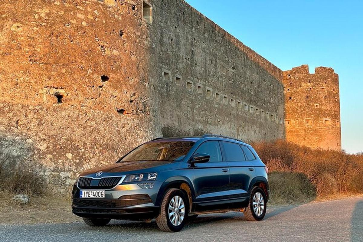 um SUV azul estacionado em frente a um muro