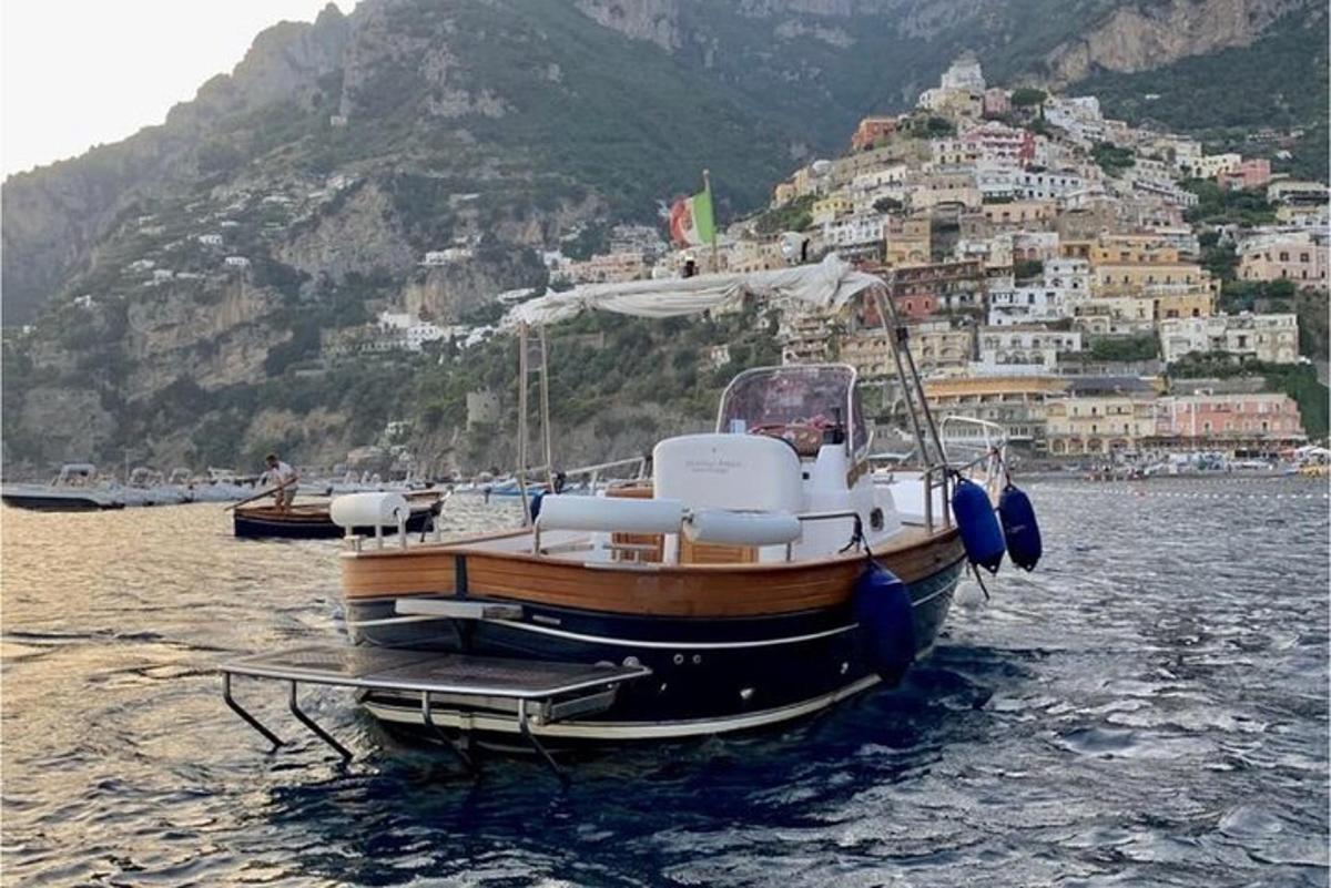 μια βάρκα που κάθεται στο νερό με ένα βουνό