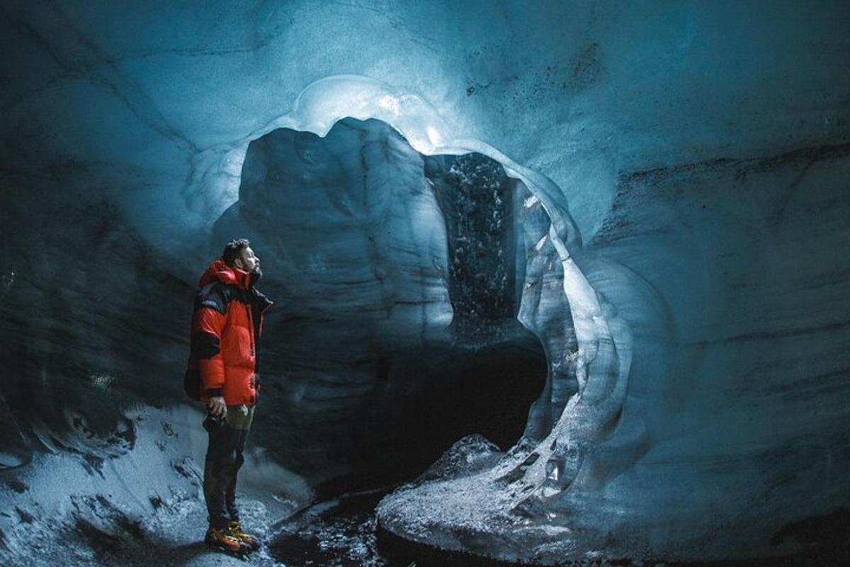 un uomo è in piedi in una grotta di ghiaccio