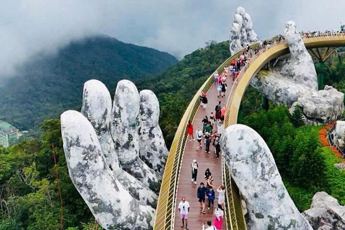 un gruppo di persone che attraversa un ponte dorato su una montagna