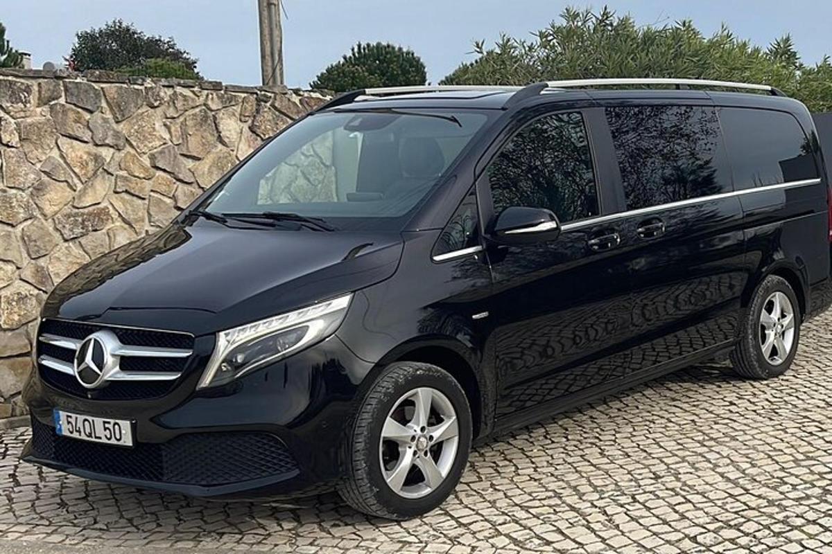 một chiếc xe SUV màu đen đỗ cạnh một bức tường đá