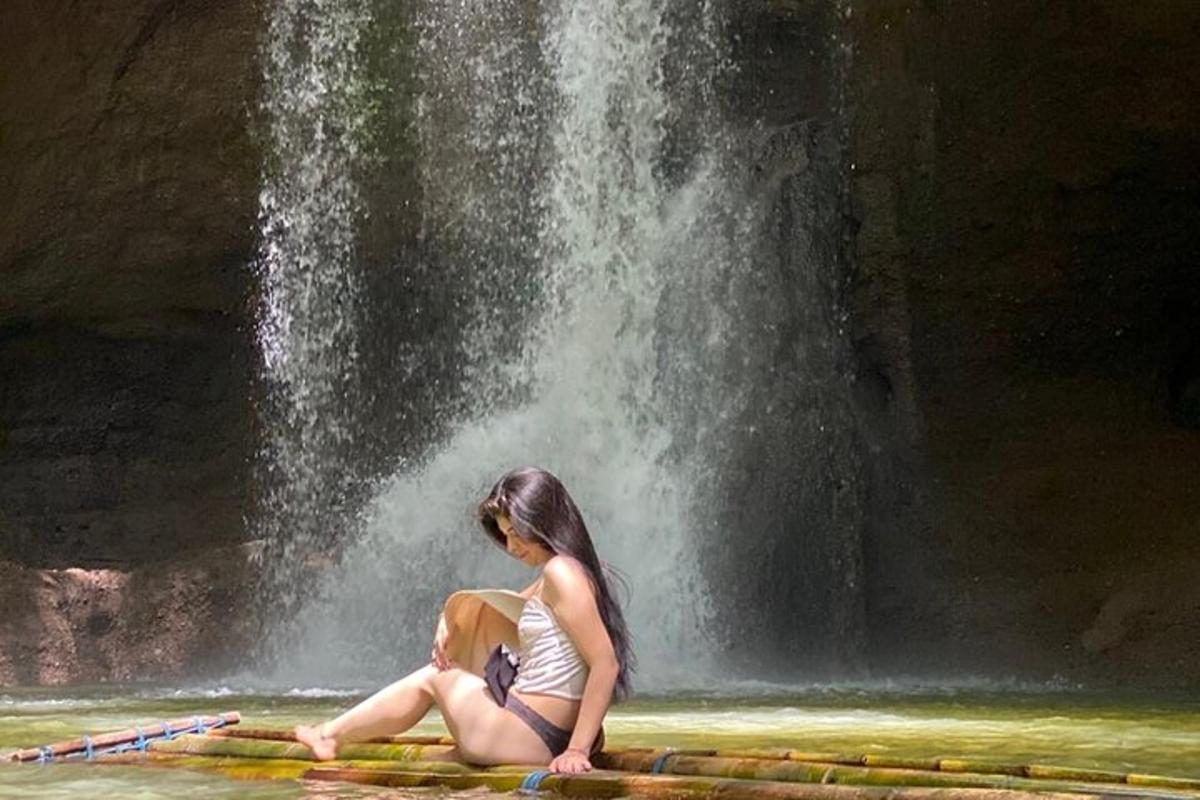 seorang wanita duduk di hadapan air terjun