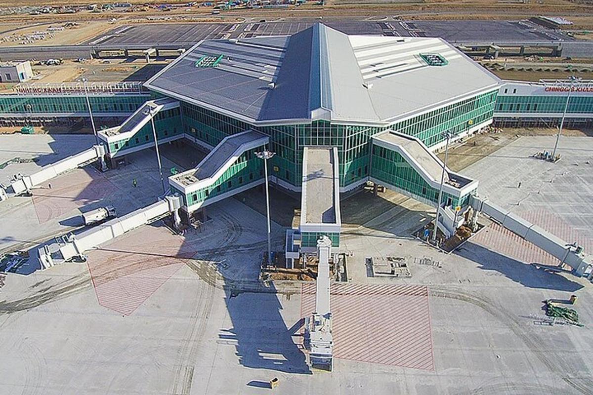 ein großes Gebäude mit einem Bahnhof an einem Flughafen